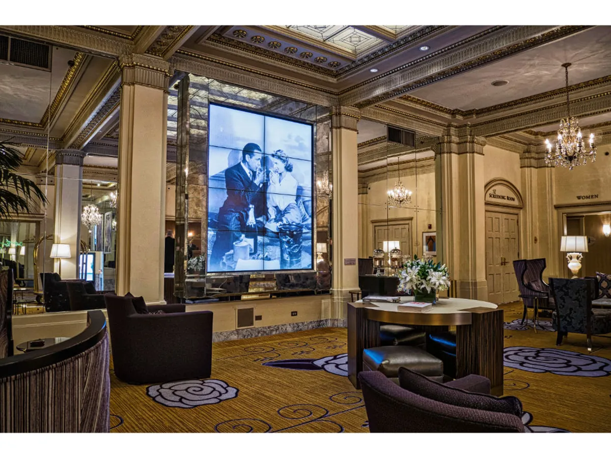 An inviting space with elegant chandeliers, refined furniture, and a prominent black and white image displayed on the wall. The ambiance is historic and sophisticated, suited for both business meetings and relaxed gatherings.